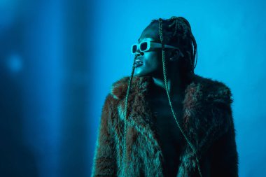 Mavi ışıklı örgülü çekici zenci kadın, kürk mantoya kopya yapıştırıcı.