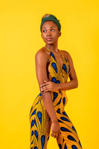 African young woman in the studio on a yellow background, portrait in a traditional costume