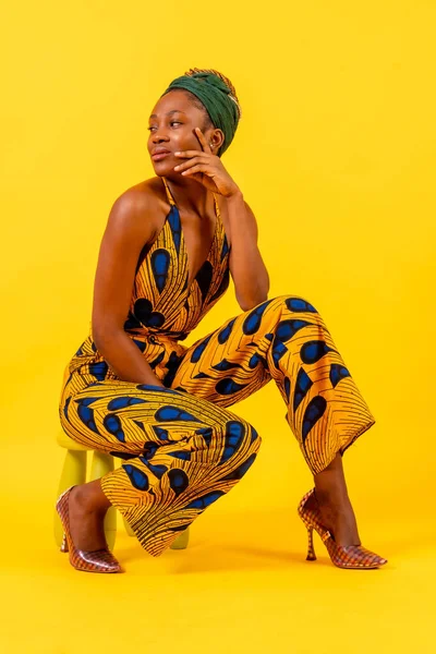 Mujer Joven Africana Vestido Tradicional Sobre Fondo Amarillo Sentado Estudio — Foto de Stock