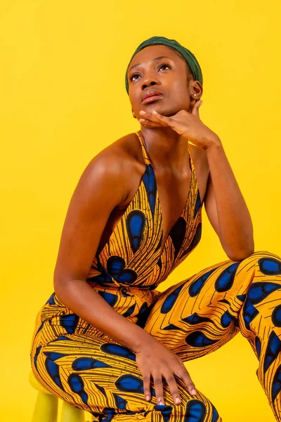 Mujer Joven Africana Vestido Tradicional Sobre Fondo Amarillo Sentado Estudio — Foto de Stock