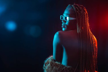 Mavi ve kırmızı ışıklı siyah etnik kadın, arkadan model, şehvetli poz.