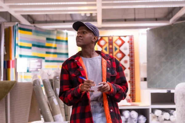 stock image Black ethnic man shopping in a carpet supermarket, buying prices