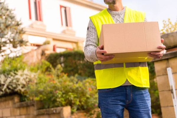 stock image Parcel delivery carrier with a box from an online store, unrecognizable person