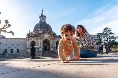 Bir anne ve oğlu, Azpeitia Barok Kilisesi, Loyola Sığınağı 'nda yerde oturuyorlar.