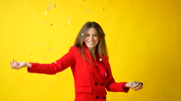 Woman Smiling Red Dress Yellow Background Throwing Confetti Party Concept — Stockvideo