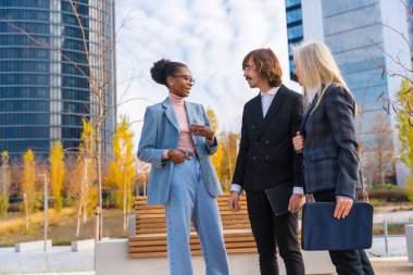 Multi ethnic business colleagues or executives talking to each other in a business park