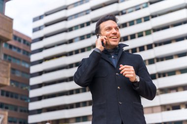 Middle-aged Caucasian businessman talking on the phone in the city, copy space