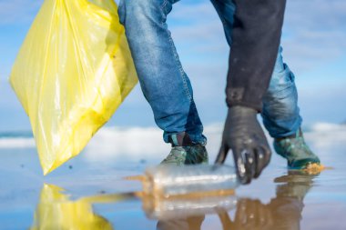 Sea pollution, unrecognizable person collecting garbage and plastic on the beach. ecology concept