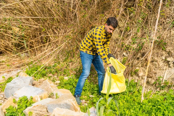 Portrait of man collecting garbage in a forest. Ecology, clean nature from plastics