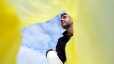 Volunteer throwing a plastic bottle into a garbage bag on the beach. Ecology, Sea pollution