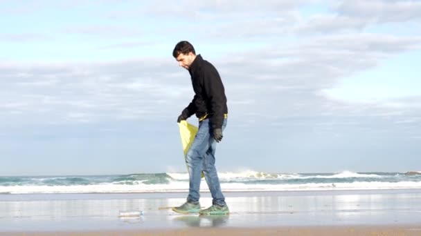 男人在海滩上捡垃圾或塑料 生态概念 海洋污染 — 图库视频影像