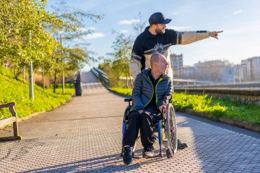 A disabled person in a wheelchair with an assistant enjoying a walk in the city
