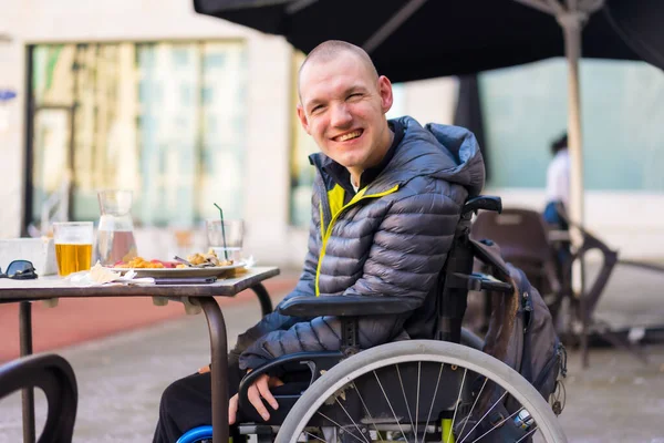 Portrait of a disabled person in a wheelchair in a restaurant, normality of disabled people