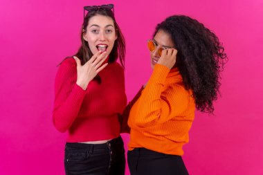 Female friends in sunglasses having fun pink background, studio shot, lifestyle