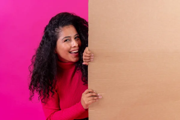 Curly Haired Woman Holding Sign Smiling Pink Background Studio Shot — Fotografia de Stock