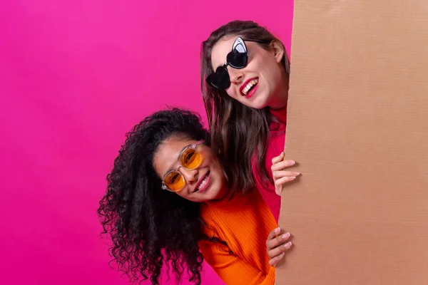 Two Smiling Beautiful Girl Friends Hold Cardboard Sign Pink Background — Φωτογραφία Αρχείου