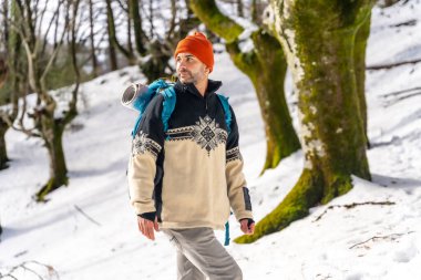 Hiker with backpack walking on a trekking on the snow, winter adventures, nature activity