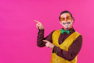 Clown with white facial makeup showing an empty space from the pink background, announcing something