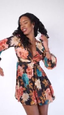 Mulatto woman having fun dancing on a white background, cuban traditional dance