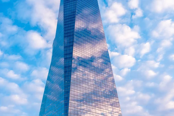 Reflection of clouds in a glass building, financial area seen from below at sunrise, modern office building