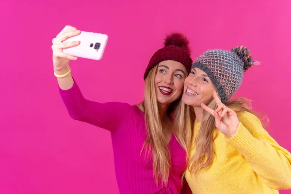 Two Young Blonde Caucasian Women Phone Isolated Pink Background Selfie — Φωτογραφία Αρχείου