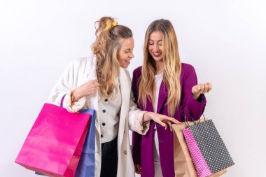 İki genç beyaz sarışının alışveriş konsepti. Satışların tadını çıkarıyorlar. Kağıt torbalar.