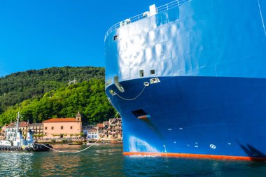 Cargo ship transporting a giant ship in the bay of Pasaia to the open sea Pasajes, Gipuzkoa, Spain