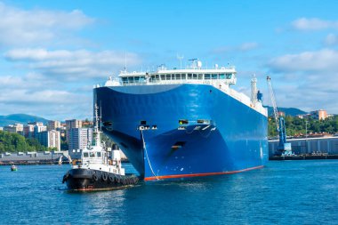 Cargo ship transporting a giant ship in the bay of Pasaia to the open sea Pasajes, Gipuzkoa, Spain