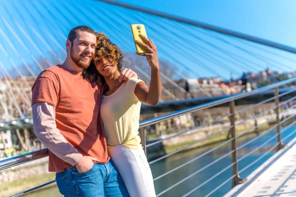 Multiracial couple through the city streets, lifestyle, selfie smiling by the river on vacation