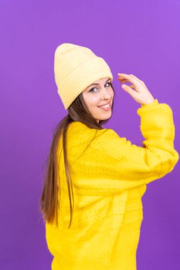 Close up portrait of young caucasian woman in yellow wool sweater isolated on yellow studio background