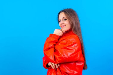 Close up portrait of a young woman, cheerful or laughing isolated on blue studio background