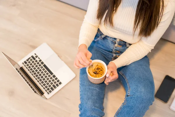 一个女人的手 带着电脑坐在沙发上 热咖啡 千年社交媒体 — 图库照片