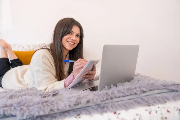 在床上使用笔记本电脑 远程办公 远程工作 在议程上写作的妇女 — 图库照片