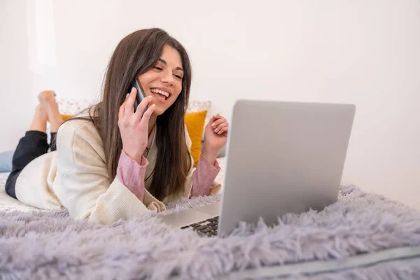 在床上带着笔记本电脑 远程办公 远程办公 在电话上微笑的女人 — 图库照片