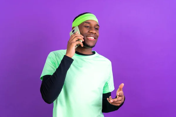Černý Etnický Muž Telefonem Zelených Šatech Izolovaných Přes Fialové Pozadí — Stock fotografie