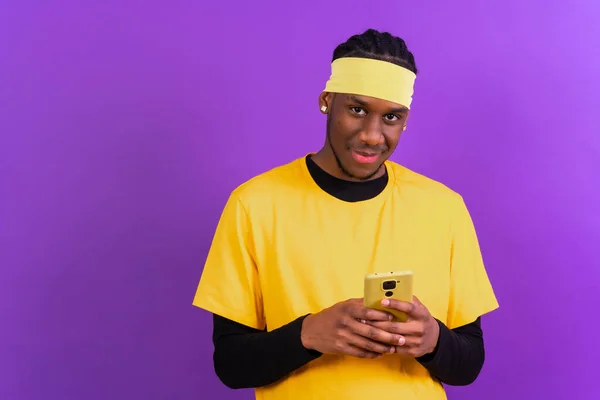 Černý Etnický Muž Telefonem Žlutém Oblečení Fialovém Pozadí — Stock fotografie
