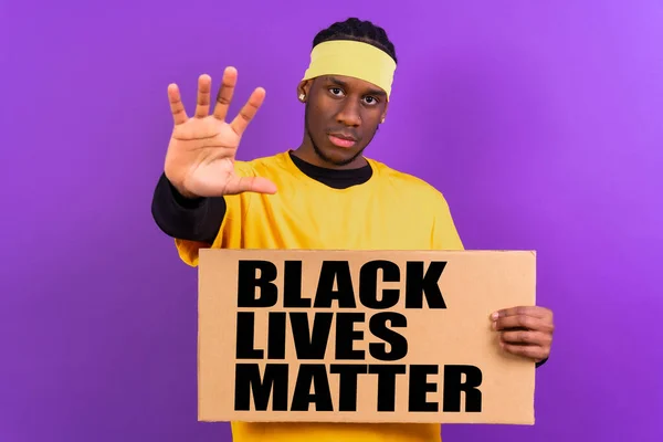 Чорний Етнічний Чоловік Жовтому Одязі Фіолетовому Тлі Вказуючи Тримає Знак — стокове фото
