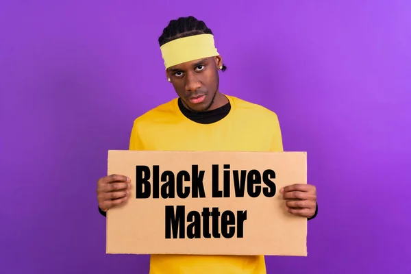 Чорний Етнічний Чоловік Жовтому Одязі Фіолетовому Тлі Вказуючи Тримає Знак — стокове фото