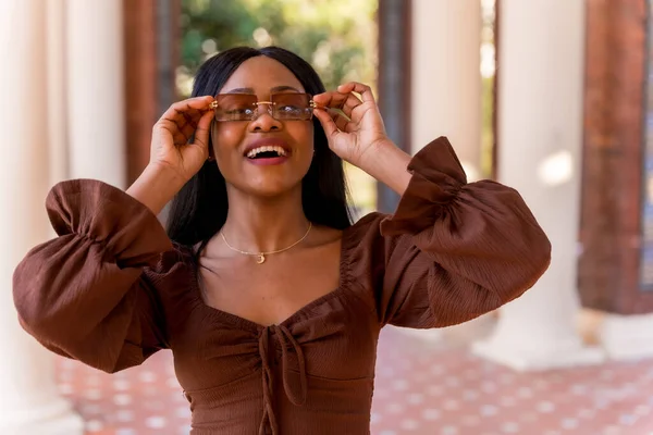 공원을 거닐면서 아름다운 아프리카 여성의 선글라스를 웃으며 — 스톡 사진