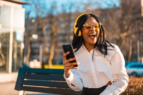 Αφροαμερικανή Γυναίκα Που Ακούει Μουσική Ακουστικά Ηλιοβασίλεμα Στην Πόλη Χαμογελώντας — Φωτογραφία Αρχείου