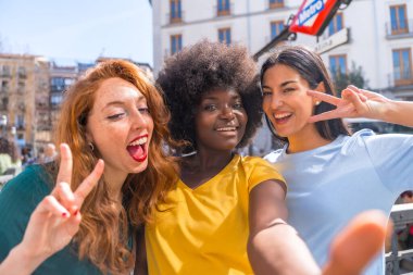 Şehirde selfie çeken çok ırklı genç kadınlar, arkadaşlık ve feminizm, eğlenmek.