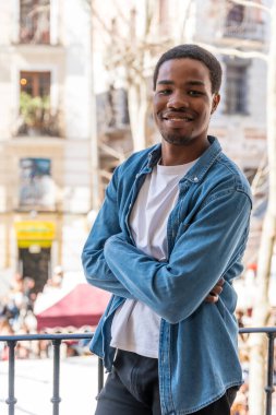 Kentteki balkon korkuluklarında genç siyah ırkın portresi