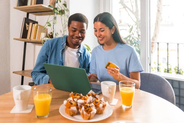 stock image Couple making purchase online with the computer while having breakfast, next to the window, shopping on the internet