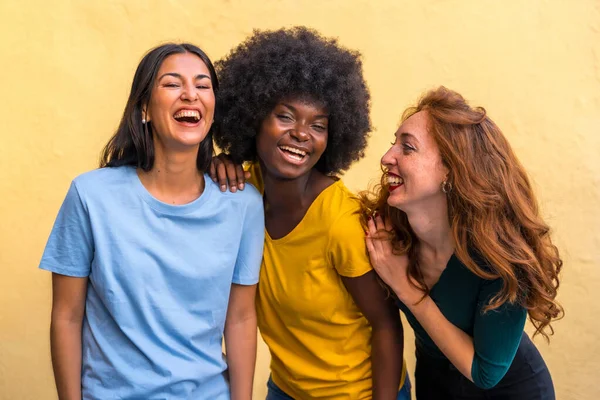 美丽的多民族女性朋友在黄墙上笑的画像 — 图库照片