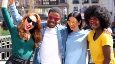 Şehir sokaklarında kalp gözlüğü takan mutlu çoklu etnik arkadaşların portresi, açık havada birlikte gülüyorlar.