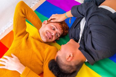 Güzel eşcinsel çift evde gökkuşağı bayrağı üzerinde romantik, lgbt konsepti