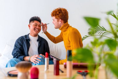 Güzel eşcinsel çift makyaj yapıyor ve evde romantik olmak eğlenceli, lgbt konsepti