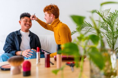 Güzel eşcinsel çift makyaj yapıyor ve kanepede romantik olmak eğlenceli, Igbt konsepti