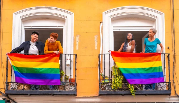 在一个家庭派对上 男同性恋和女同性恋者的夫妇在阳台上挂着Lgtb国旗 — 图库照片
