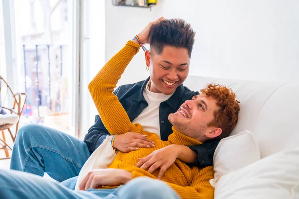 美丽的一对同性恋情侣在家里躺在沙发上浪漫地拥抱在一起 — 图库照片